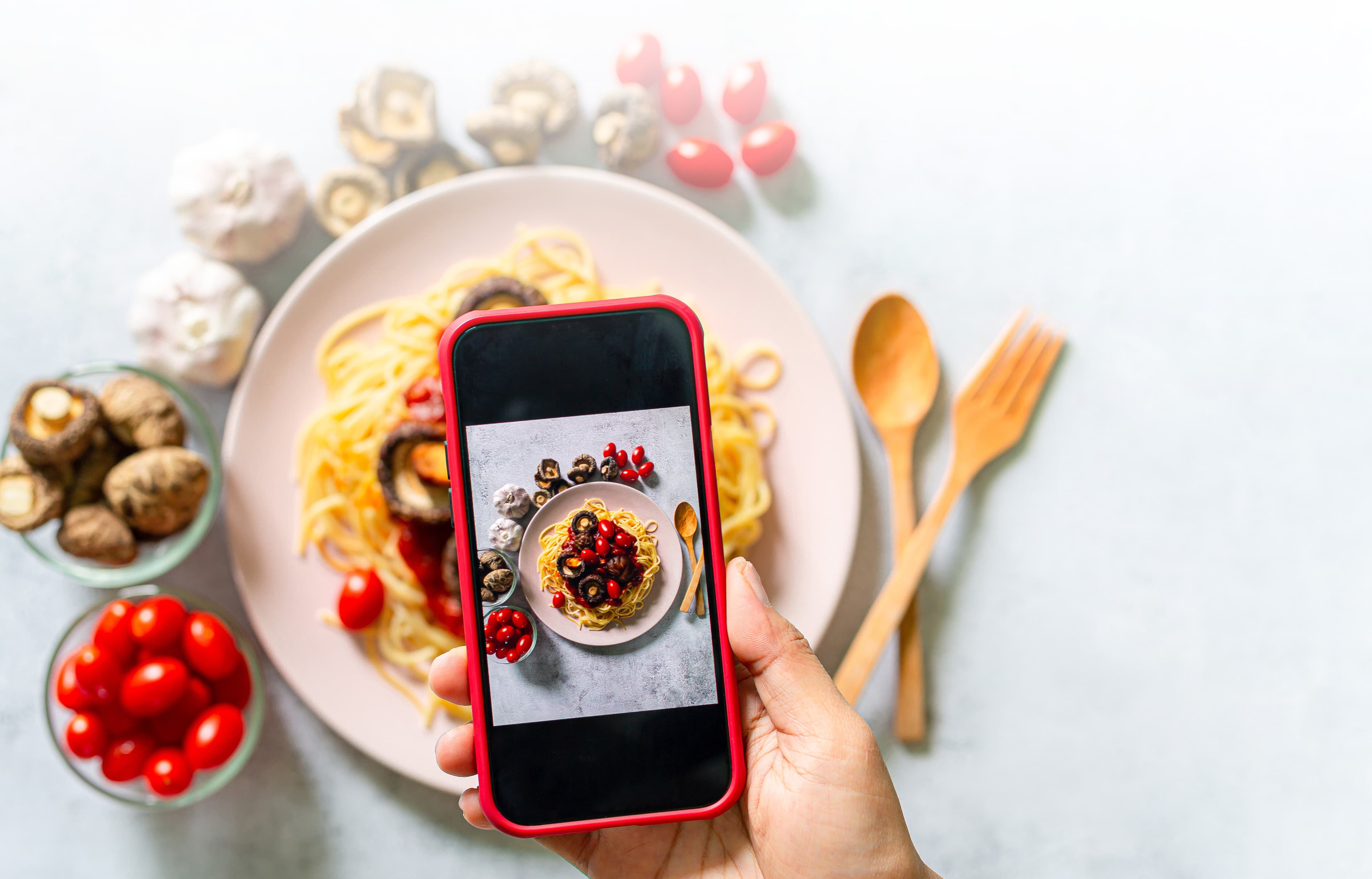 Hand snapping a plant-based meal with phone