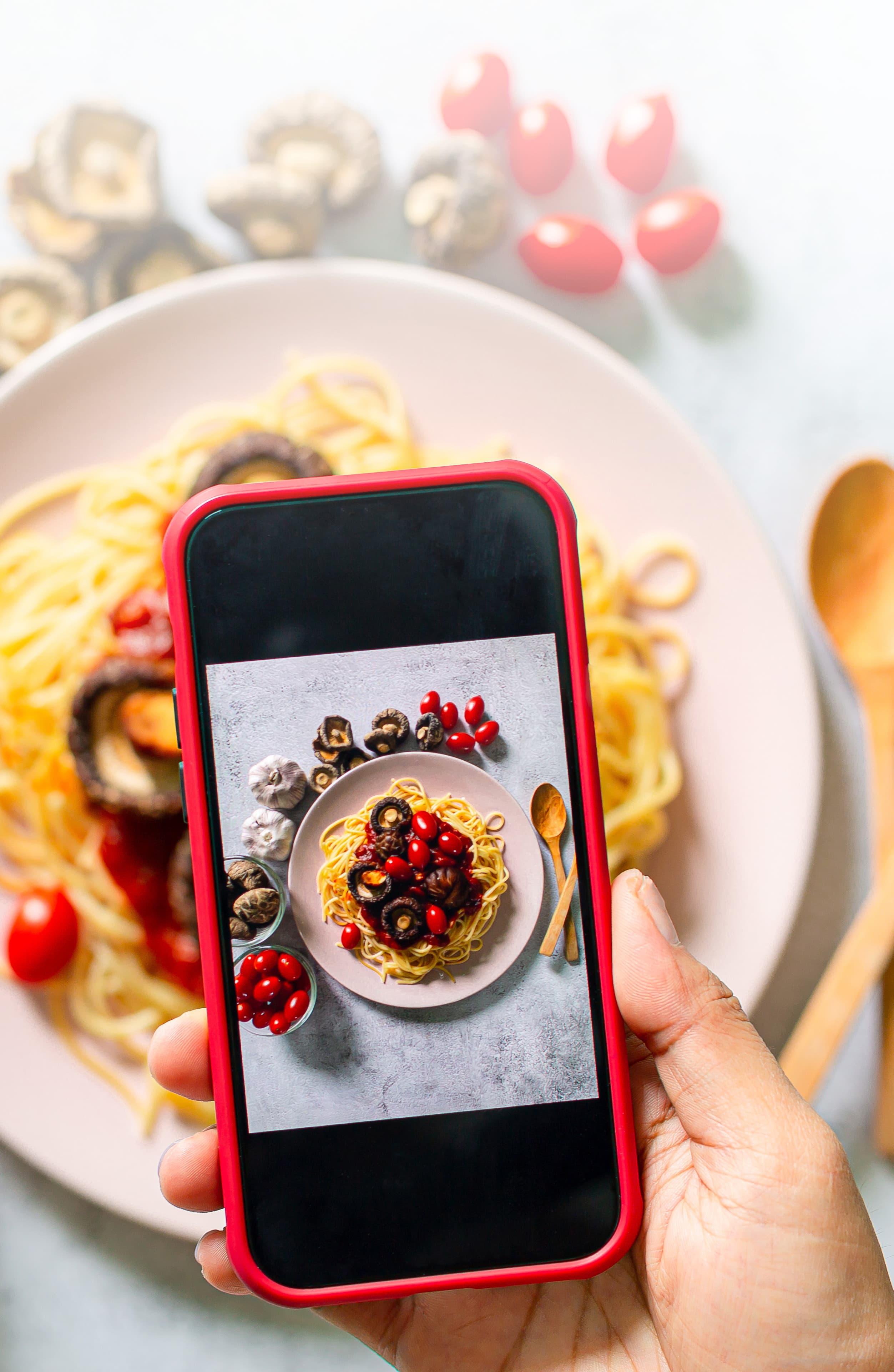 Hand snapping a plant-based meal with phone